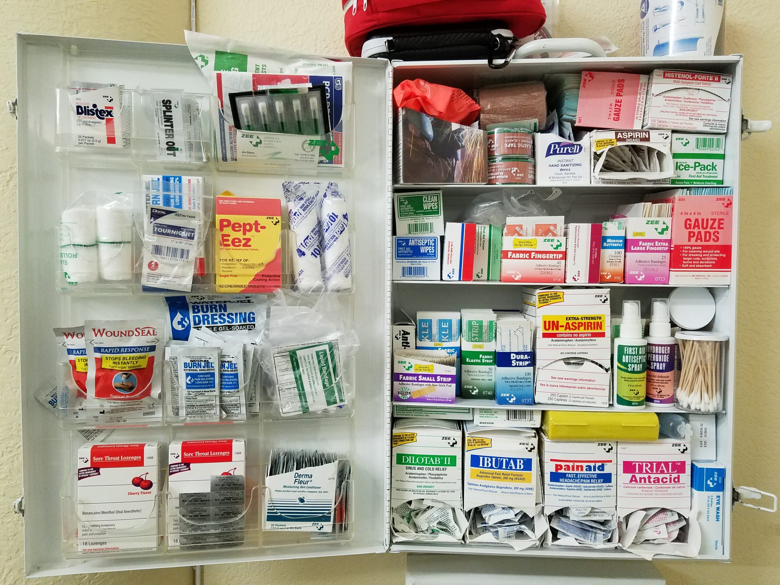 First Aid Kit filled with supplies, mounted to the wall