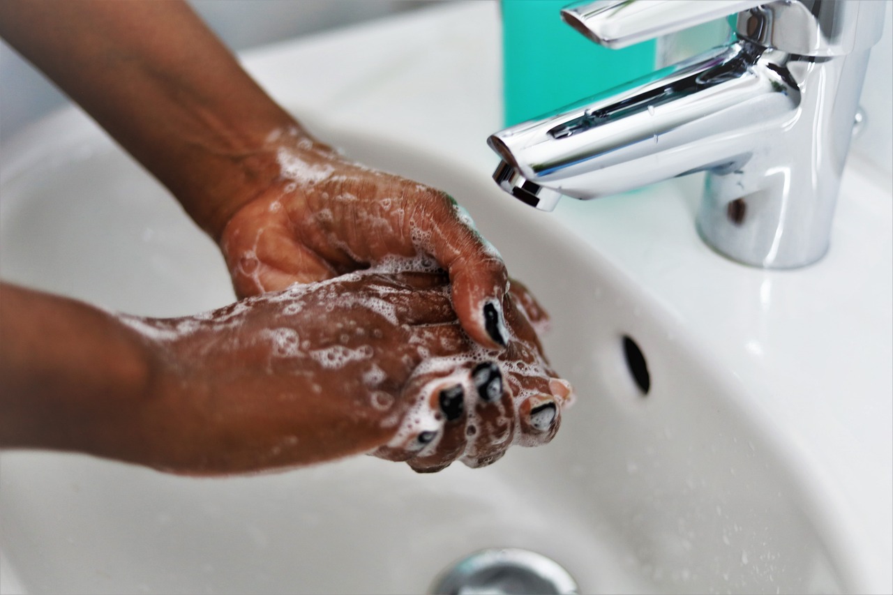 washing hands in a sink with soap and water
