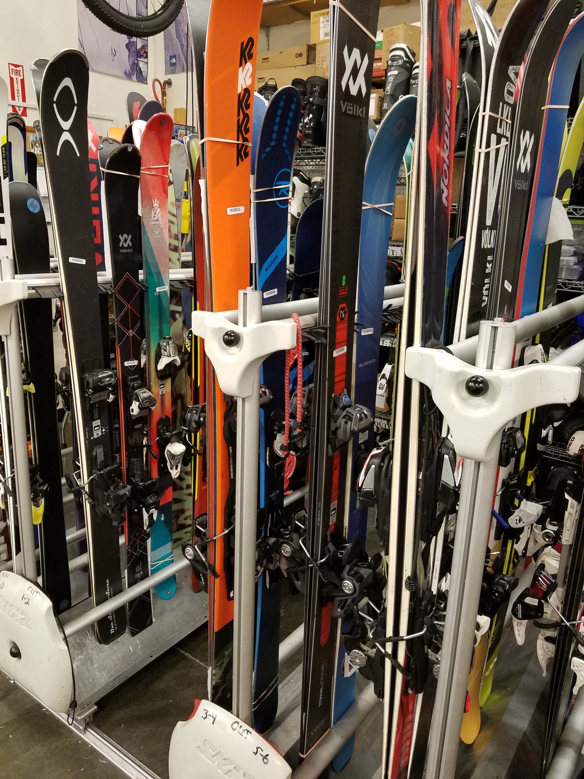 Skis and snowboards in racks waiting to be waxed
