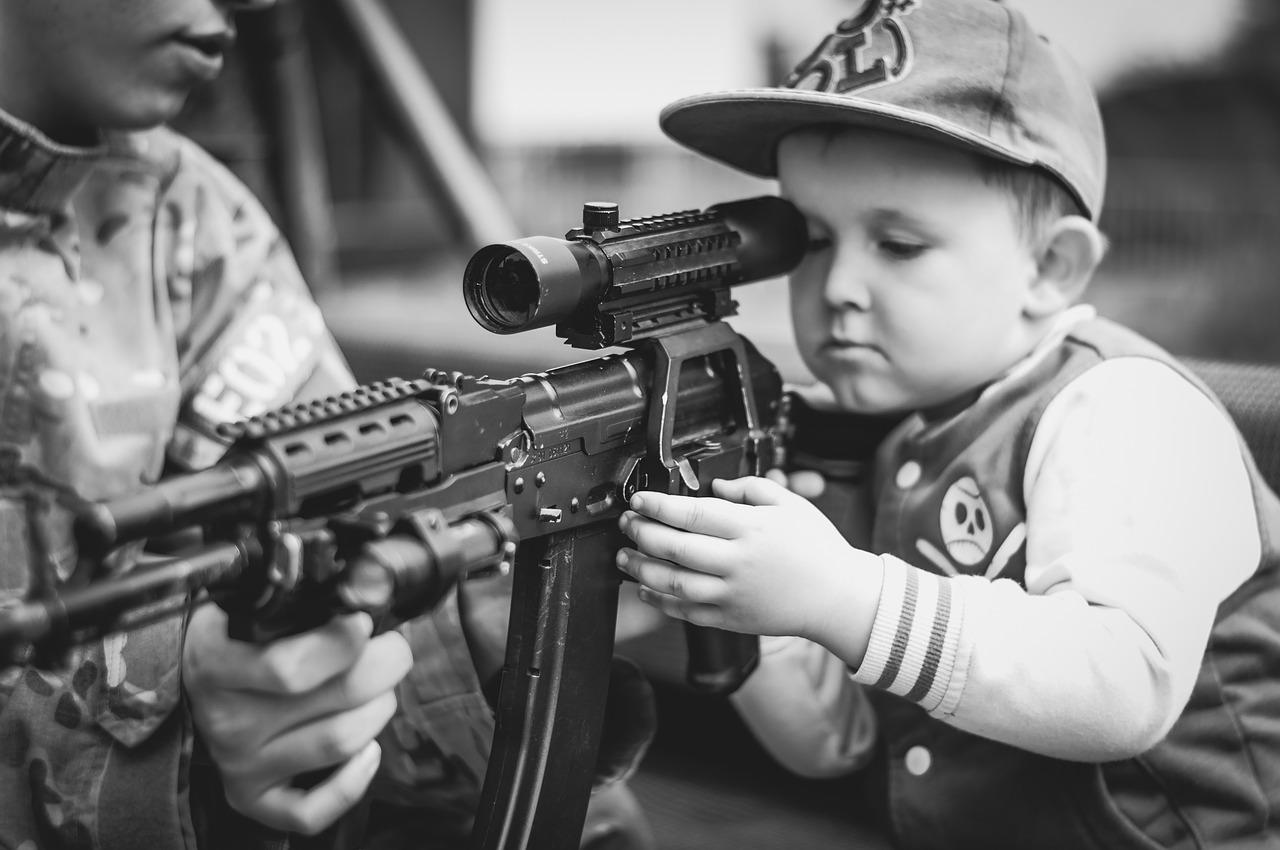 boy learning to shoot proper firearm handling