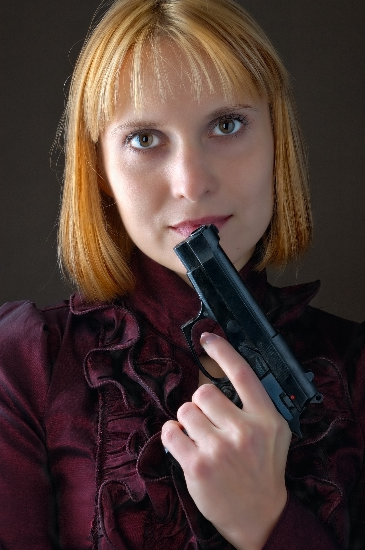 girl holding firearm incorrectly, never put your finger on the trigger until you are ready to shoot