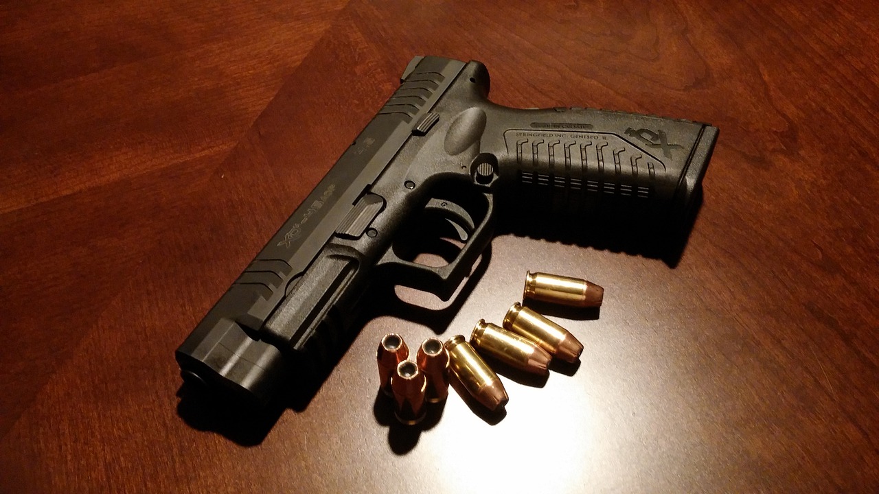 handgun and ammo on a desk